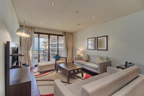 a living room with a couch and a table at Luxe Getaways Royal Amwaj Palm Jumeirah Resort Apartment Holiday Home in Dubai