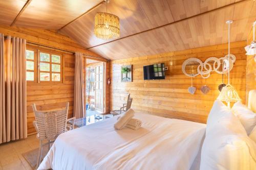 a bedroom with a white bed in a room with wooden walls at Lakala Complexe Touristique in O Ben Slimane
