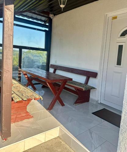 a picnic table and bench in a room with a door at Hilltop Family House Panoramic Views in Dobrnja