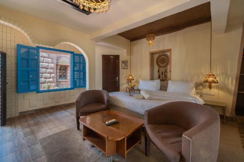 a bedroom with a bed and two chairs and a table at Lakala Complexe Touristique in O Ben Slimane