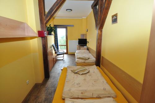 a hallway with two beds in a room with yellow walls at Hotel Na Hradbách in Louny