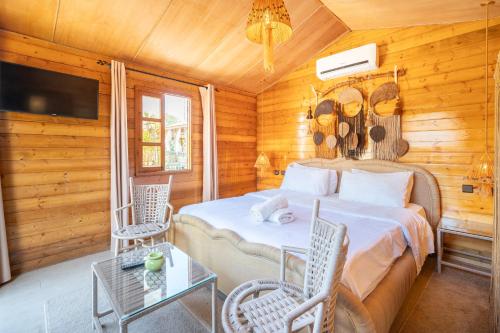 a bedroom with a bed and chairs and a tv at Lakala Complexe Touristique in O Ben Slimane