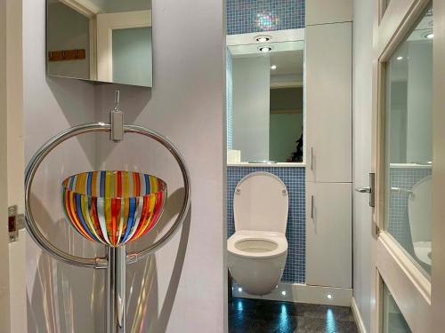 a small bathroom with a toilet and a mirror at Farnham Haven: Unique Home with Courtyard in Farnham