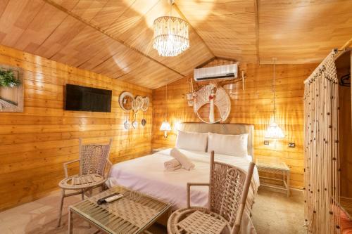 a bedroom with a bed and chairs and a tv at Lakala Complexe Touristique in O Ben Slimane
