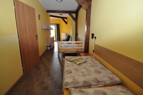 a small room with a bed and a hallway at Hotel Na Hradbách in Louny