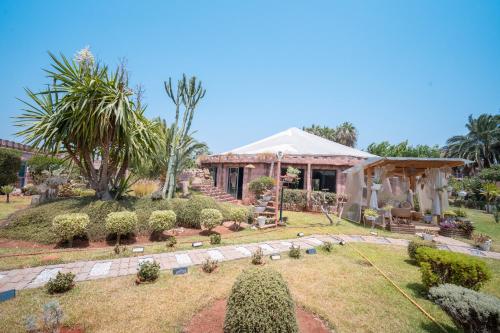 a house with a garden in front of it at Lakala Complexe Touristique in O Ben Slimane