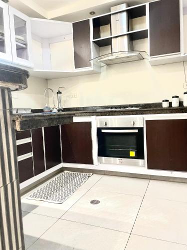 a kitchen with brown cabinets and a microwave at Residencias Daja in La Asunción