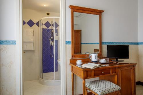 a bathroom with a desk with a television and a shower at Hotel Alessandrino in Rome