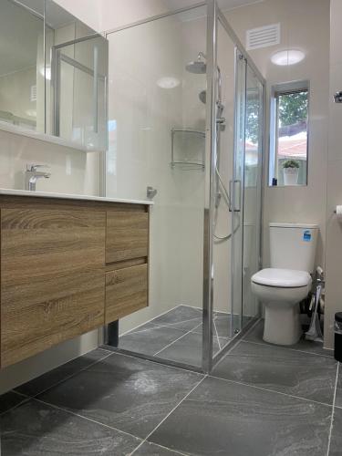 a bathroom with a toilet and a glass shower at Beachfront Apartment in Melbourne
