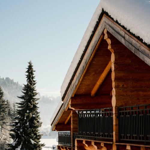 a log cabin with snow on the roof at Clofers Leisure Lodges Jenig in Jenig