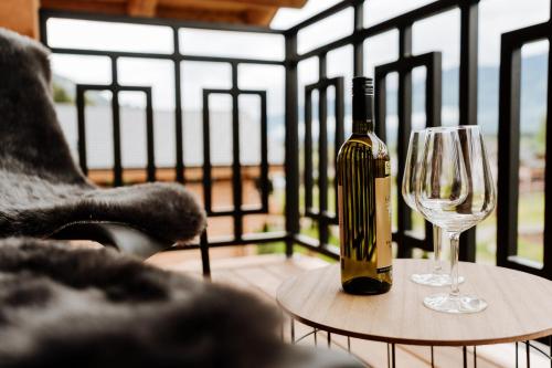 a bottle of wine sitting on a table next to a wine glass at Clofers Leisure Lodges Jenig in Jenig