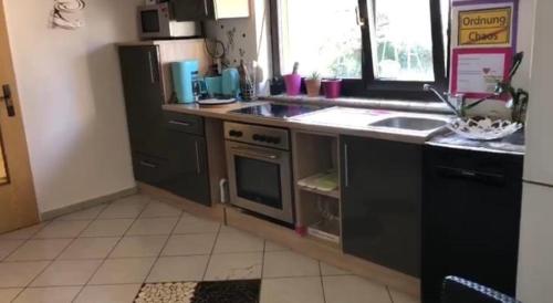 a kitchen with a sink and a stove top oven at Gemütliches Ferienhaus nahe Playmobil in Zirndorf - Ideal für Familien und Entdecke in Zirndorf