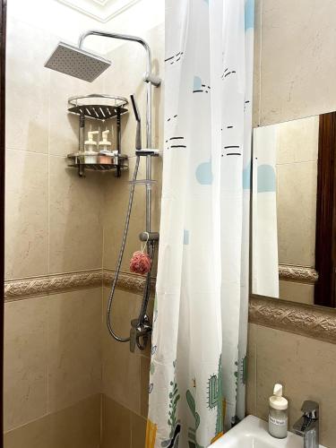 a shower with a white shower curtain in a bathroom at Dar EL BAHIA - Spacious flat with large Terrace in Casablanca