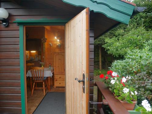 an open door to a garden room with flowers at Bungalow Brandl in Zinnowitz