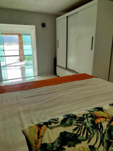 a bedroom with a large bed with a window at Pousada Onda de Mar in Angra dos Reis