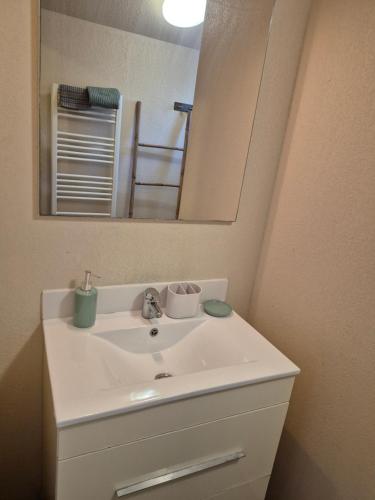 une salle de bains avec un lavabo blanc et un miroir dans l'établissement Zéphyr, à Saint-Christol