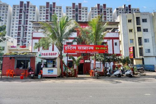ein Gebäude mit Palmen vor hohen Gebäuden in der Unterkunft Hotel O Krishna Executive in Pune
