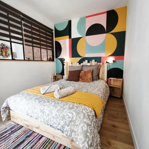 a bedroom with a bed and a colorful wall at Maison Sorbier, Appartement 1 in Nevers