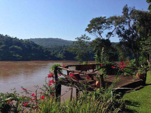 a boat on the side of a river with flowers at La Mision Mocona - Lodge de Selva in Saltos del Moconá