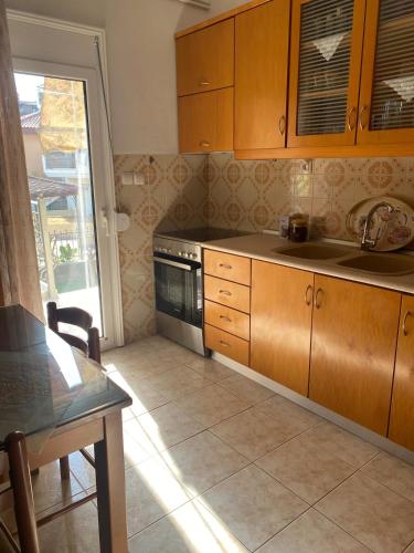 a kitchen with wooden cabinets and a sink and a table at Soula House in Kavallárion