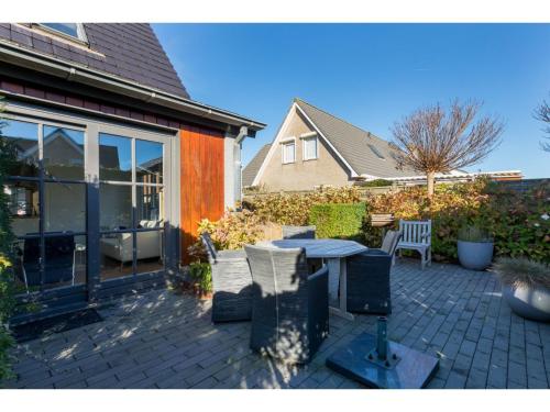 a patio with a table and chairs next to a house at Apartment in Zoutelande near the Beach in Zoutelande