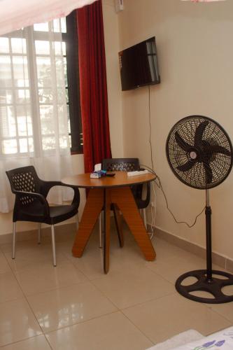 a dining room with a table and a fan at Amigo apartments in Kisumu