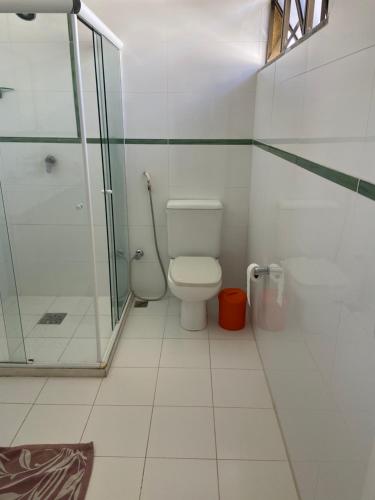 a bathroom with a toilet and a glass shower at casa bela in Lauro de Freitas