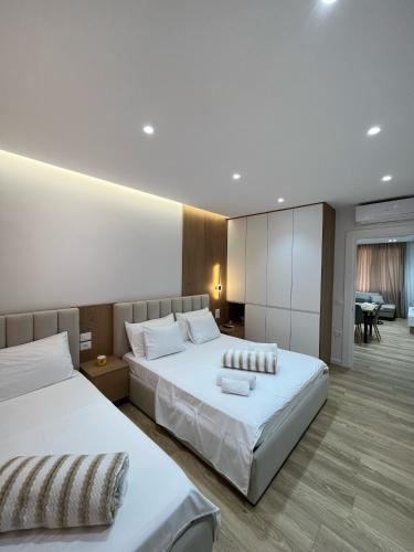 a hotel room with two beds and a living room at Mimi's Apartment in Durrës