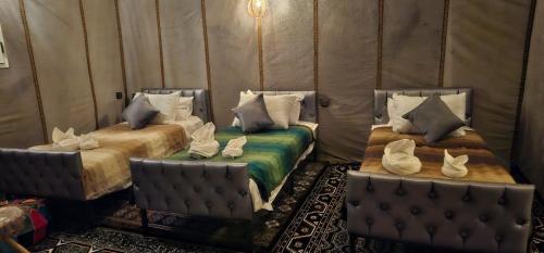 a room with two beds with pillows at Luxury Desert Queen Camp in Merzouga