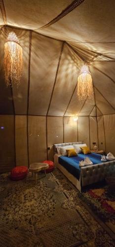 a bedroom with a bed in a tent at Luxury Desert Queen Camp in Merzouga