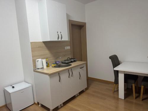 a small kitchen with a sink and a table at Apartmani Bella in Krževići