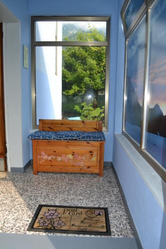 a room with a large window and a wooden dresser at Ka' Tari in Ponte nellʼAlpi