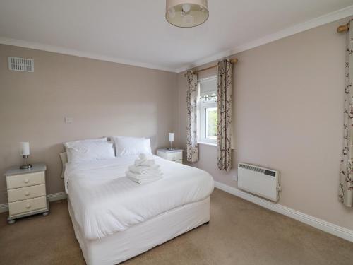 a bedroom with a white bed and a window at Dunbrody Dreams in New Ross