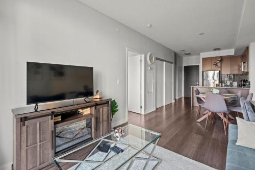a living room with a fireplace and a tv at Modern 1Bd & Den Condo with Balcony Lillian St in Toronto