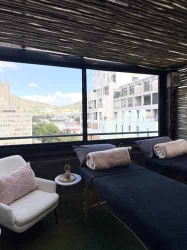 a living room with couches and a large window at Cape Diamond Boutique Hotel in Cape Town