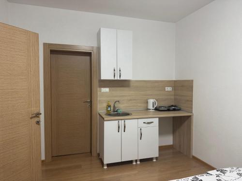 a small kitchen with a sink and a door at Apartmani Bella in Krževići