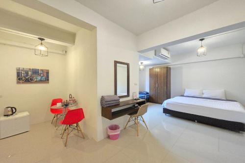 une chambre avec un lit, un bureau et des chaises dans l'établissement Hotel Wualai by CMStay, à Chiang Mai