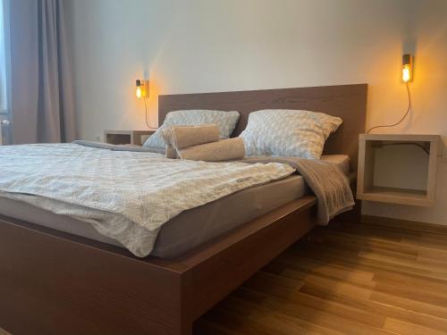a bedroom with a large bed with two lamps on it at Cozy Corner by Bytko in Nitra