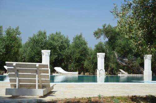 a pool with a chair and a slide in a yard at Agriturismo Masseria San Leonardo in Savelletri di Fasano