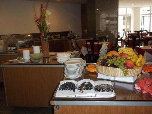 a table with bowls of fruit and plates on it at Costa do Mar Hotel in Fortaleza
