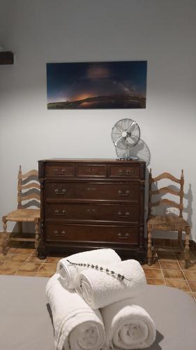 a room with a dresser with towels and a fan at Casa Rural Mar de Encinas in Cabañas del Castillo