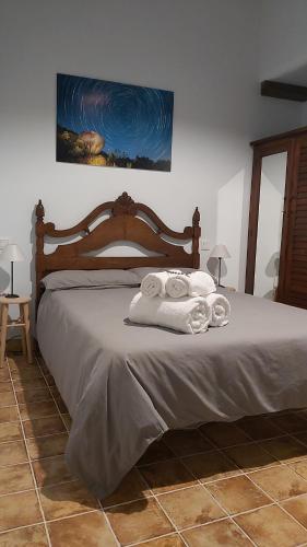 a bedroom with a bed with towels on it at Casa Rural Mar de Encinas in Cabañas del Castillo
