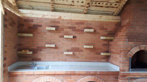a brick kitchen with a sink in a brick wall at Casa Ionel si Dani in Fundata