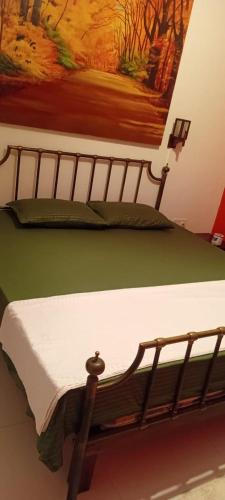 a bed in a room with a painting on the wall at Queens Leisure Villa Bambukuliya in Kochchikade