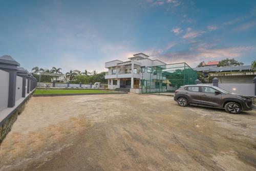 a car parked in a parking lot in front of a building at Courtyard Villa by Tropicana Stays in Lonavala