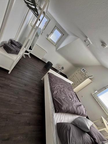 a bedroom with a bed and a loft with windows at FeWo Büdingen - Atelier in Büdingen