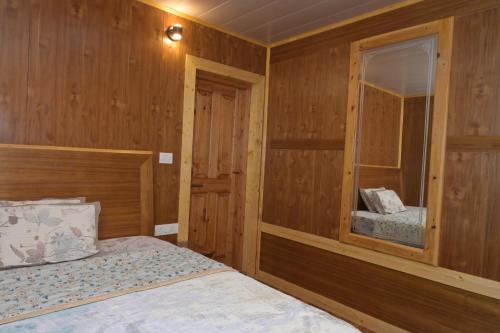 a bedroom with a bed with a wooden wall at Neha Homestay in Shimla