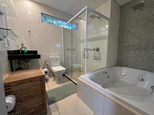 a white bathroom with a tub and a toilet at Villela Stay - Aluguel de Suítes e Quartos - Lago Sul in Brasilia