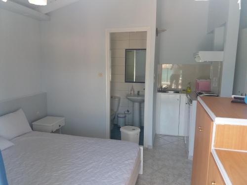 a small white bedroom with a bed and a sink at Steven in Vasiliki