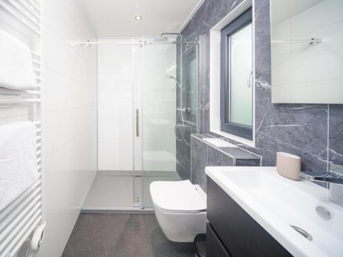 a bathroom with a shower and a toilet and a sink at Cozy Mamer Lodge with Private Hot Tub - 4 Guests in Fouhren